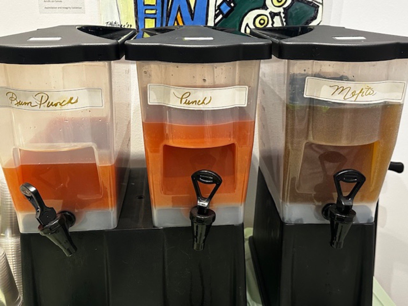 Three beverage dispensers labeled rum punch, punch, and mojito.