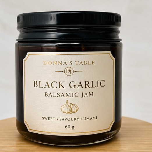 Black Garlic Balsamic Jam in an amber glass jar with a Donna's Table label.